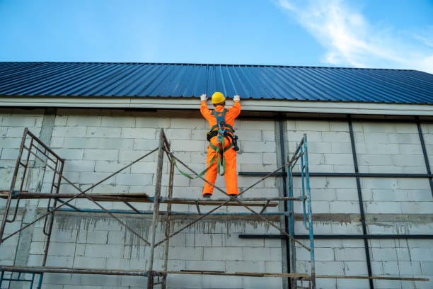 Roof worker on commercial roof with safety harness