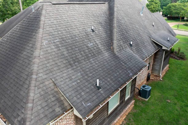 Wind-damaged roof shingles peeled back and lifted on a Colorado Springs home